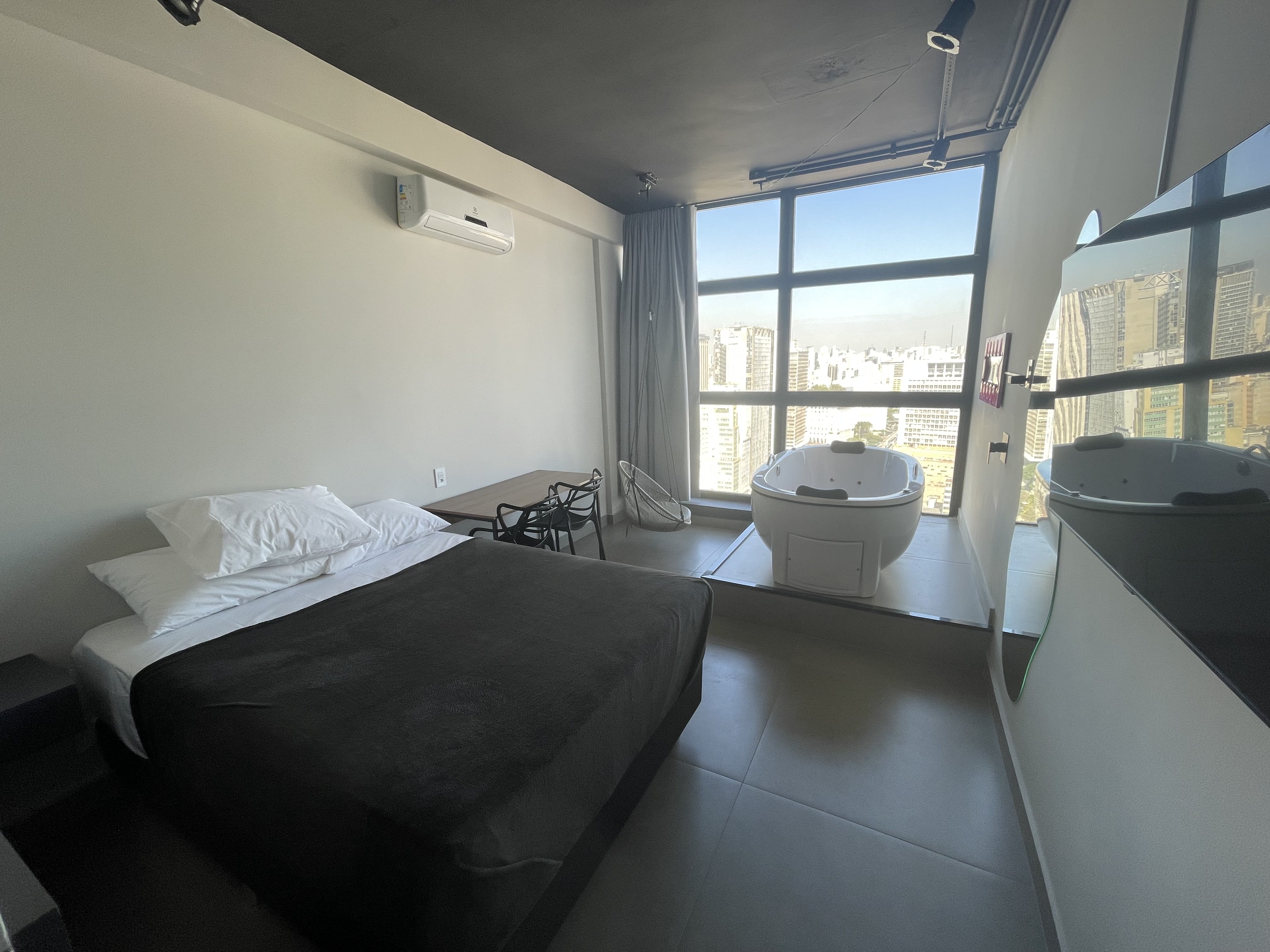 Suíte com jacuzzi privativa e vista panorâmica de São Paulo